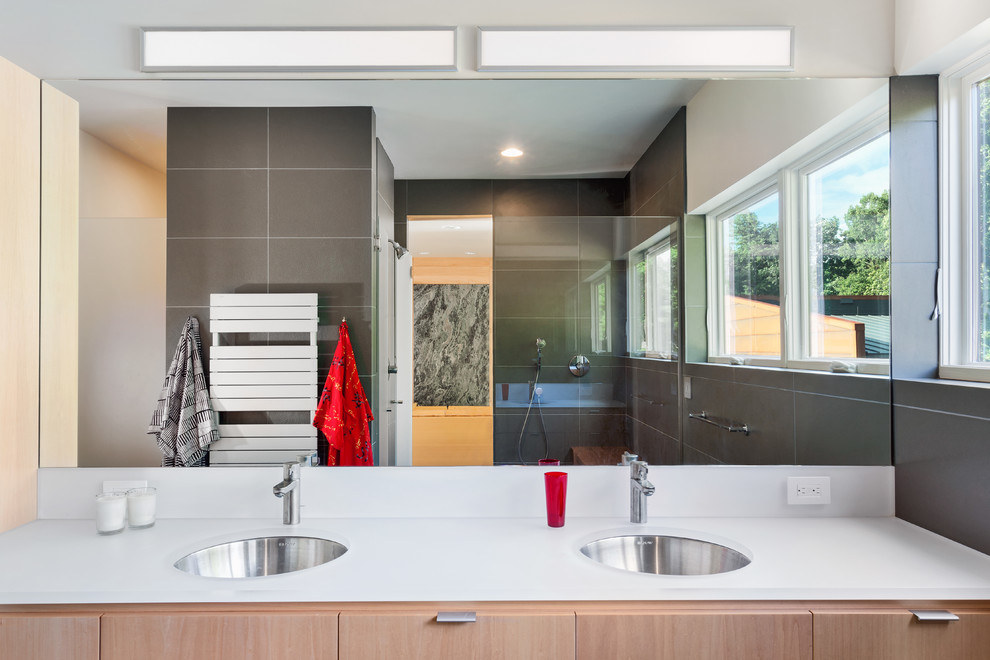 На фото: главная ванная комната среднего размера в современном стиле с врезной раковиной, светлыми деревянными фасадами, открытым душем, серой плиткой, керамогранитной плиткой, белыми стенами и плоскими фасадами