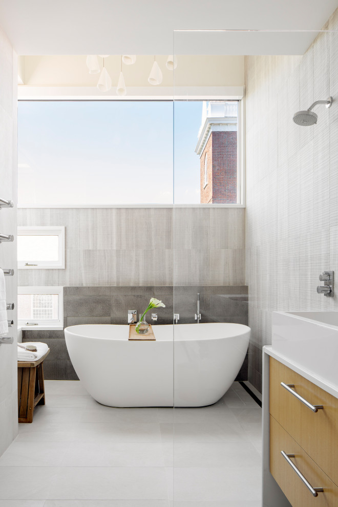 Inspiration for a mid-sized modern master gray tile and cement tile concrete floor and gray floor bathroom remodel in Boston with flat-panel cabinets, light wood cabinets, a one-piece toilet, white walls, a console sink, quartzite countertops, a hinged shower door and white countertops