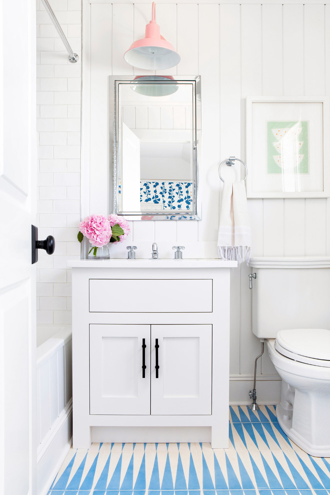 Photo of a medium sized nautical family bathroom in New York with shaker cabinets, white cabinets, an alcove bath, a shower/bath combination, white tiles, metro tiles, white walls, a submerged sink, blue floors, a shower curtain, white worktops, a two-piece toilet, ceramic flooring and engineered stone worktops.