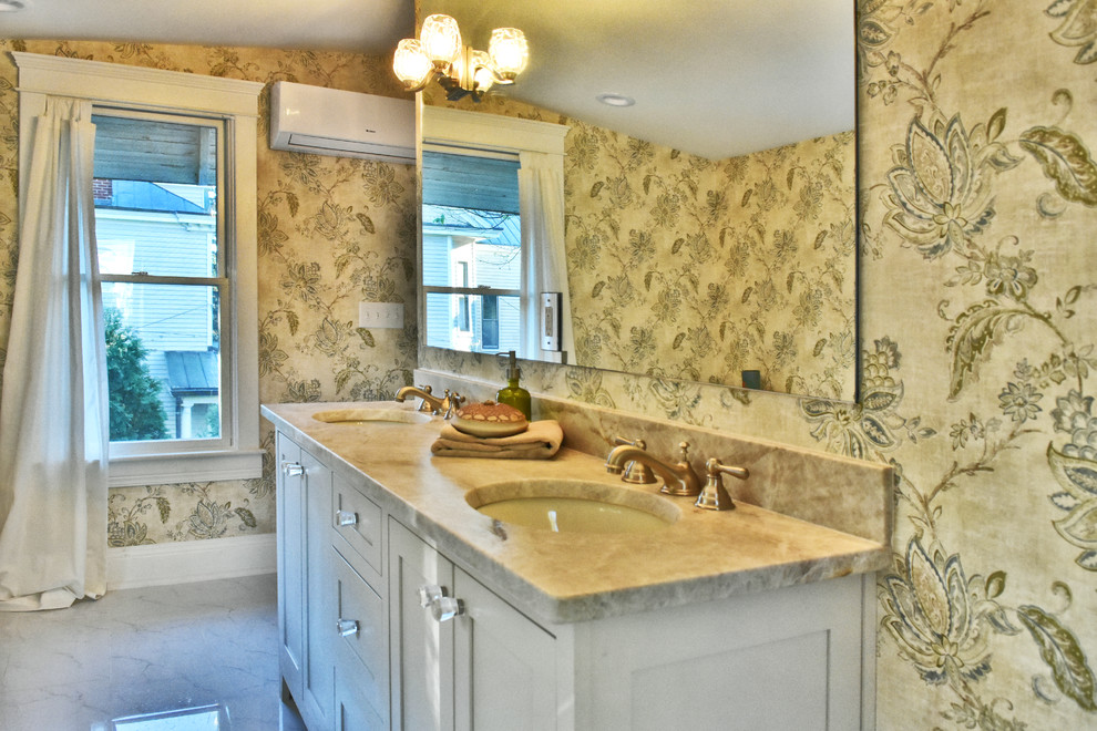 Cette image montre une salle de bain traditionnelle avec des portes de placard blanches, un sol en marbre, un plan de toilette en granite, un sol blanc et un lavabo encastré.