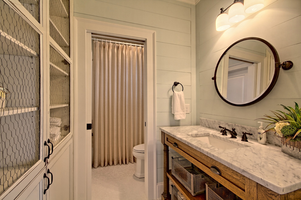This is an example of a medium sized farmhouse shower room bathroom in Atlanta with recessed-panel cabinets, distressed cabinets, a shower/bath combination, a two-piece toilet, grey walls, mosaic tile flooring and marble worktops.