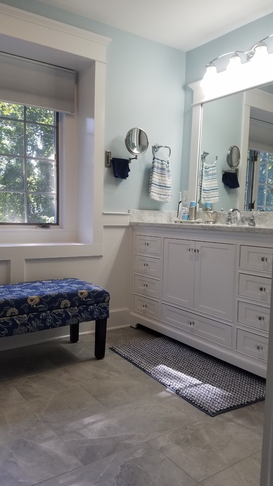 Example of a mid-sized classic master white tile and porcelain tile porcelain tile and gray floor alcove shower design in Bridgeport with shaker cabinets, white cabinets, a two-piece toilet, blue walls, an undermount sink, marble countertops and a hinged shower door