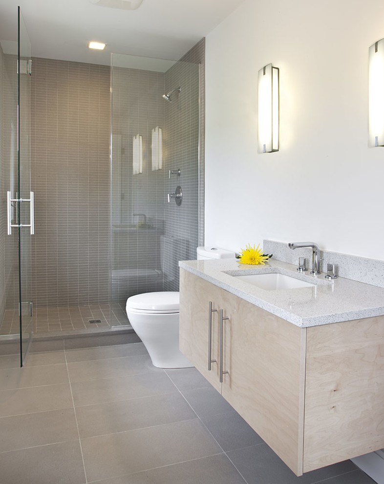 Inspiration för ett badrum med dusch, med ett undermonterad handfat, släta luckor, skåp i ljust trä, marmorbänkskiva, en toalettstol med hel cisternkåpa och vita väggar