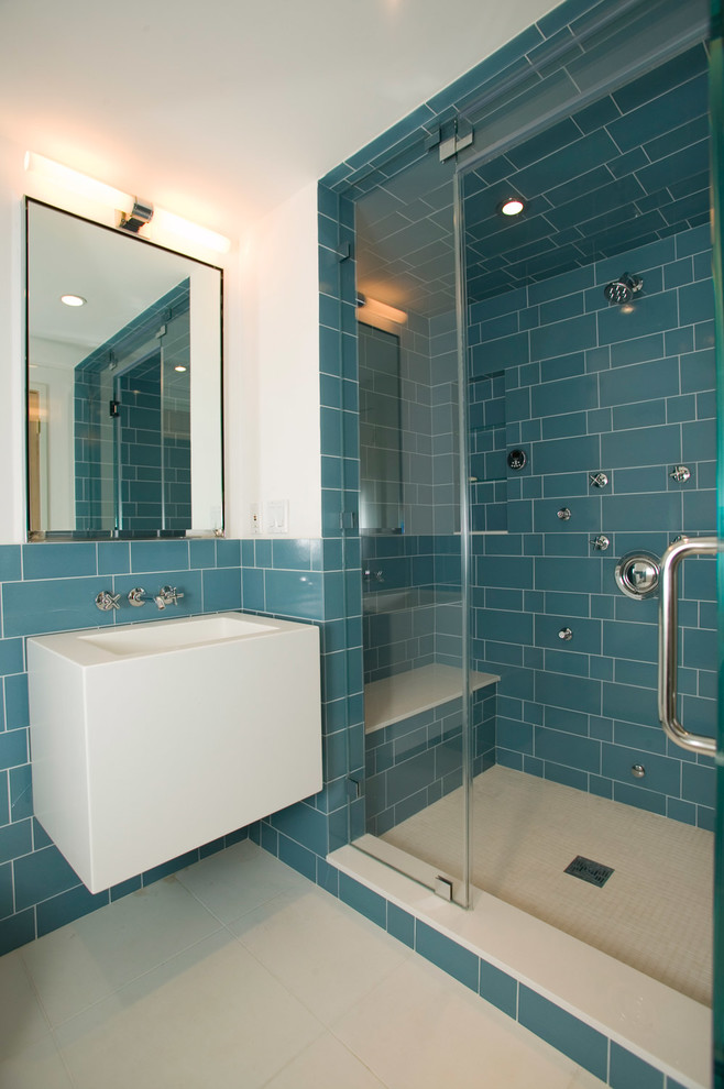 Diseño de cuarto de baño actual con lavabo integrado, ducha empotrada, baldosas y/o azulejos azules, paredes blancas y aseo y ducha