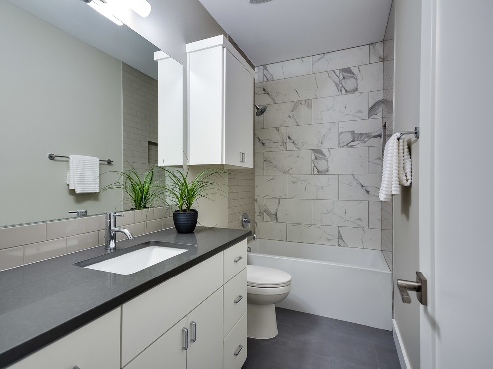 Mid-sized trendy kids' gray tile and stone slab ceramic tile bathroom photo in Austin with flat-panel cabinets, a one-piece toilet, gray walls, an undermount sink, quartz countertops and white cabinets