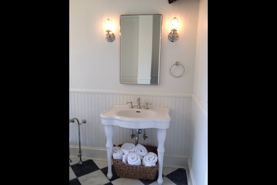 Inredning av ett klassiskt mellanstort en-suite badrum, med ett konsol handfat, ett badkar med tassar, en dusch i en alkov, en toalettstol med separat cisternkåpa, vit kakel, tunnelbanekakel, vita väggar och marmorgolv