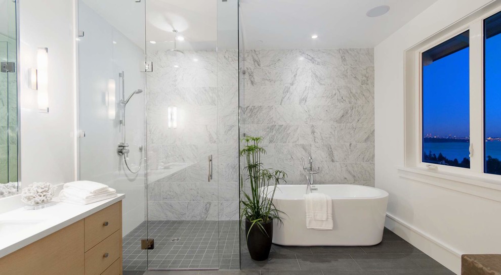 Mid-sized trendy master gray tile and porcelain tile porcelain tile bathroom photo in New York with light wood cabinets, a one-piece toilet, gray walls, an undermount sink and granite countertops