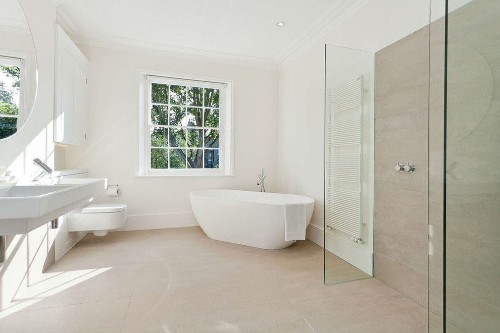 Modernes Duschbad mit freistehender Badewanne, bodengleicher Dusche, Wandtoilette, weißer Wandfarbe, Wandwaschbecken, beigem Boden und offener Dusche in Sonstige