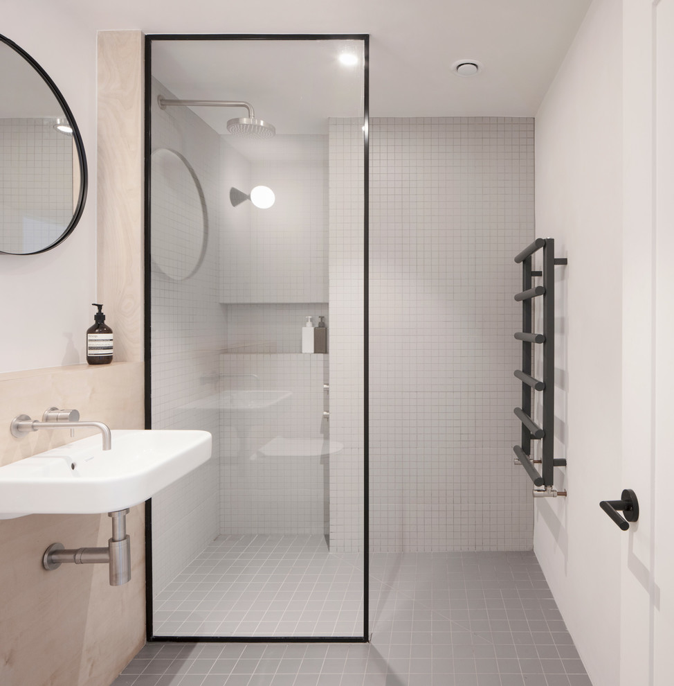 Immagine di una piccola stanza da bagno con doccia scandinava con zona vasca/doccia separata, piastrelle grigie, piastrelle a listelli, pareti bianche, lavabo sospeso, pavimento grigio e doccia aperta