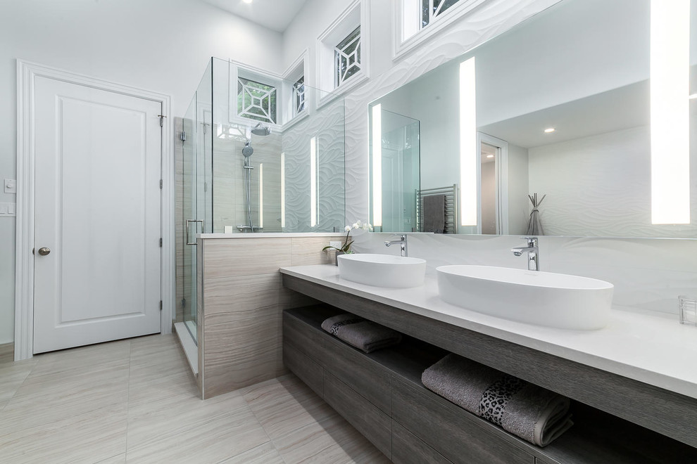 На фото: ванная комната в современном стиле с плоскими фасадами, серыми фасадами, угловым душем, белой плиткой, керамогранитной плиткой, белыми стенами, настольной раковиной, серым полом и душем с распашными дверями с