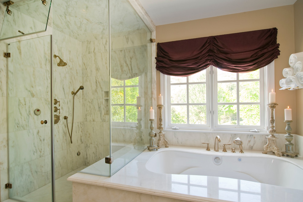 Foto de cuarto de baño principal clásico grande con encimera de mármol, bañera esquinera, ducha empotrada, paredes beige y baldosas y/o azulejos blancos