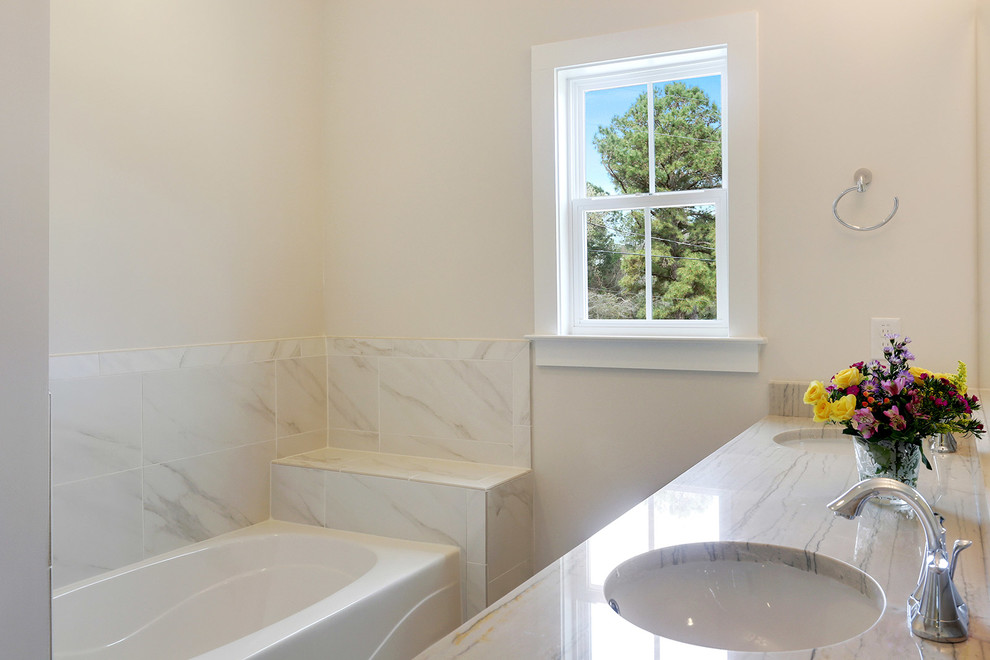 Пример оригинального дизайна: главная ванная комната среднего размера в стиле неоклассика (современная классика) с фасадами в стиле шейкер, белыми фасадами, накладной ванной, душем над ванной, белой плиткой, каменной плиткой, белыми стенами, полом из керамической плитки, врезной раковиной и столешницей из гранита