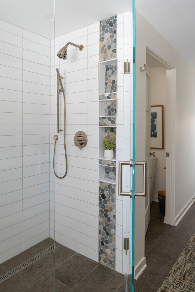Walk-in shower - mid-sized mid-century modern master white tile and subway tile porcelain tile and gray floor walk-in shower idea in Minneapolis with flat-panel cabinets, medium tone wood cabinets, a two-piece toilet, white walls, a vessel sink, quartz countertops, a hinged shower door and white countertops