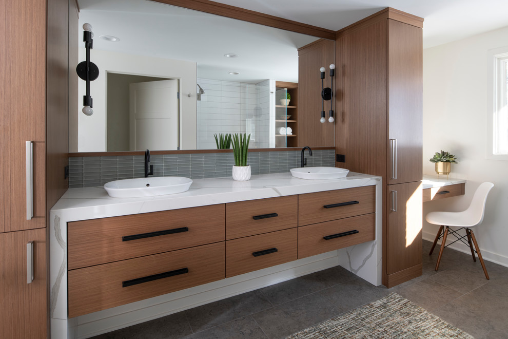 Medium sized retro ensuite bathroom in Minneapolis with flat-panel cabinets, medium wood cabinets, a built-in shower, white tiles, metro tiles, white walls, porcelain flooring, a vessel sink, engineered stone worktops, grey floors, a hinged door and white worktops.