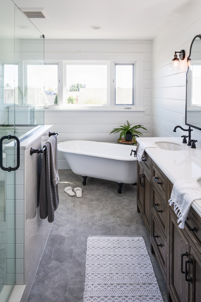 This is an example of a medium sized traditional ensuite bathroom in San Diego with freestanding cabinets, dark wood cabinets, a claw-foot bath, an alcove shower, white tiles, ceramic tiles, white walls, porcelain flooring, a submerged sink, engineered stone worktops, grey floors, a hinged door and white worktops.