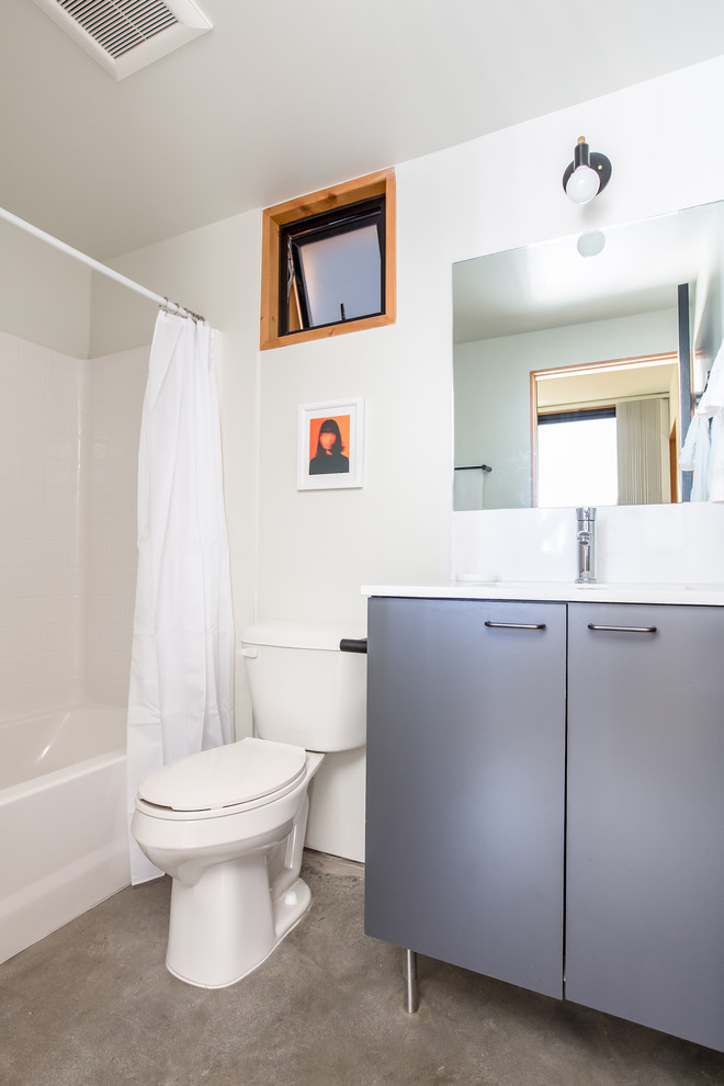 Ejemplo de cuarto de baño vintage de tamaño medio con armarios con paneles lisos, puertas de armario grises, suelo de cemento, suelo gris y encimeras blancas