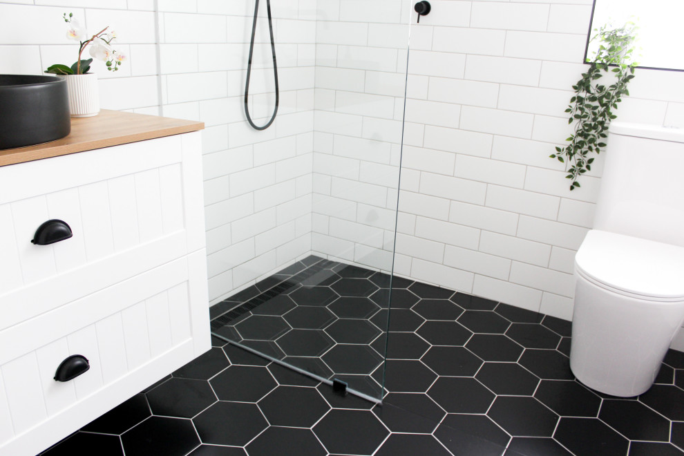 Bathroom - small modern kids' white tile and ceramic tile porcelain tile, black floor, single-sink and brick wall bathroom idea in Perth with shaker cabinets, white cabinets, a one-piece toilet, white walls, a vessel sink, wood countertops, beige countertops and a floating vanity