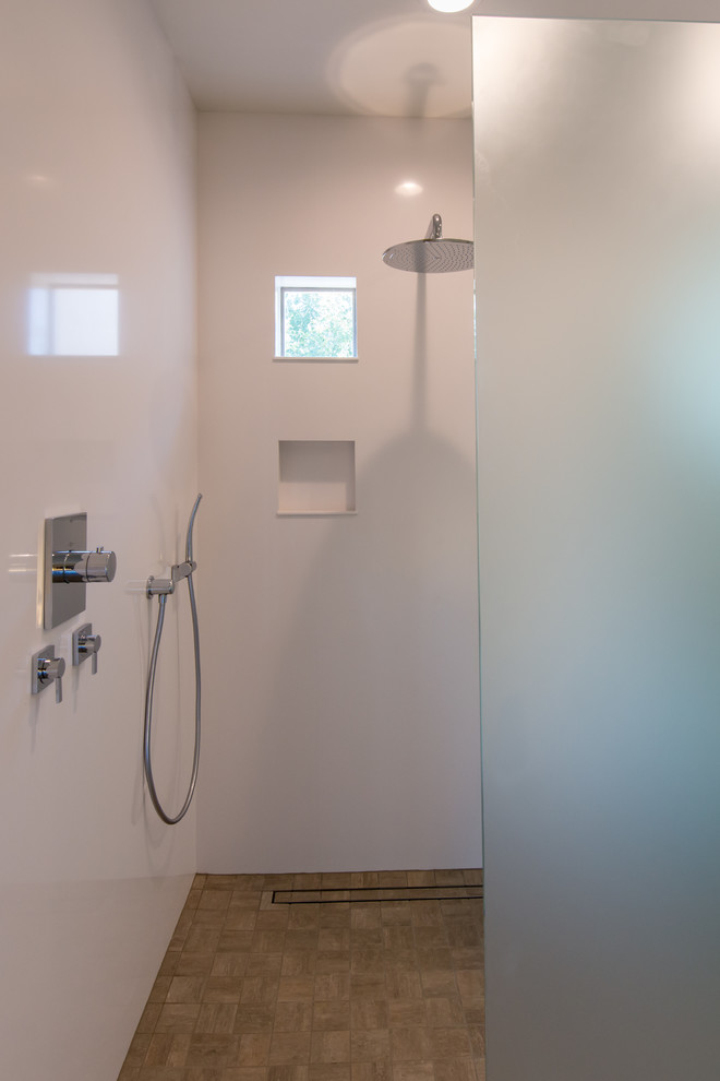 Modern inredning av ett stort en-suite badrum, med ett fristående handfat, släta luckor, vita skåp, bänkskiva i kvarts, ett fristående badkar, en hörndusch, en toalettstol med separat cisternkåpa, brun kakel, keramikplattor, vita väggar och mörkt trägolv