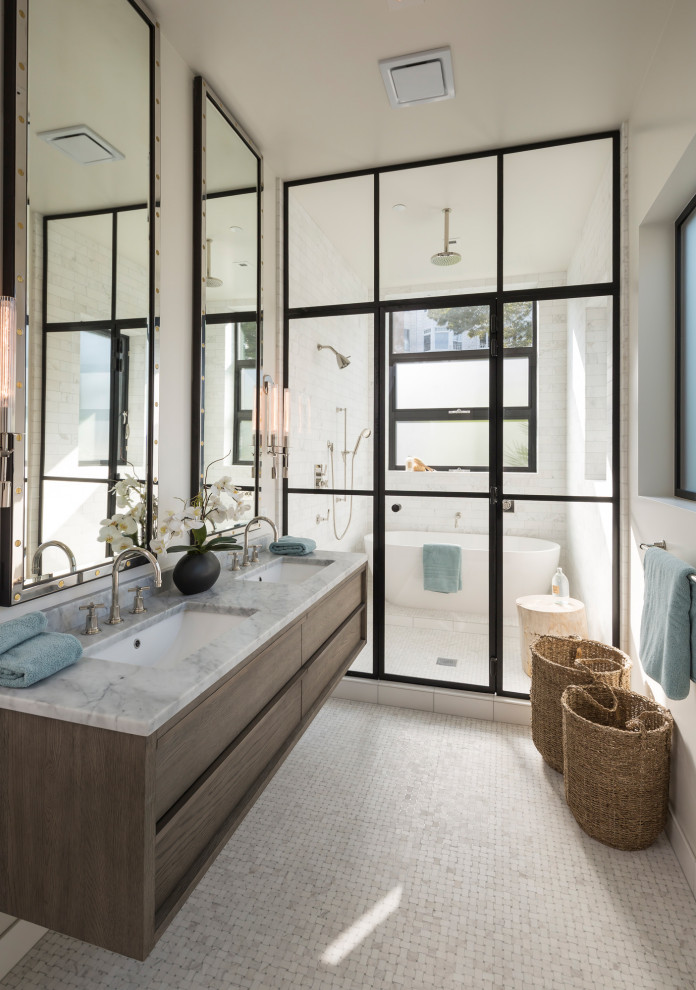 Inspiration for a large contemporary ensuite wet room bathroom in Los Angeles with flat-panel cabinets, dark wood cabinets, a freestanding bath, white tiles, white walls, mosaic tile flooring, a submerged sink, white floors, a hinged door, grey worktops, double sinks, a floating vanity unit, marble worktops and a vaulted ceiling.
