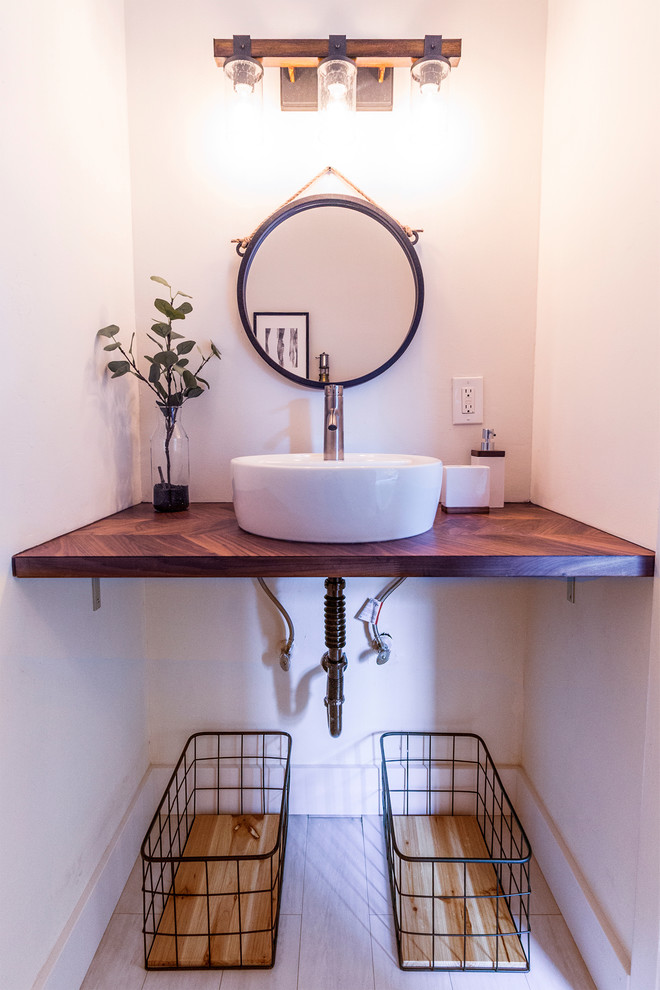 Foto på ett litet funkis brun badrum med dusch, med öppna hyllor, svarta skåp, vita väggar, laminatgolv, ett fristående handfat, träbänkskiva, beiget golv, ett badkar i en alkov, en dusch/badkar-kombination, en toalettstol med separat cisternkåpa, vit kakel, porslinskakel och dusch med duschdraperi