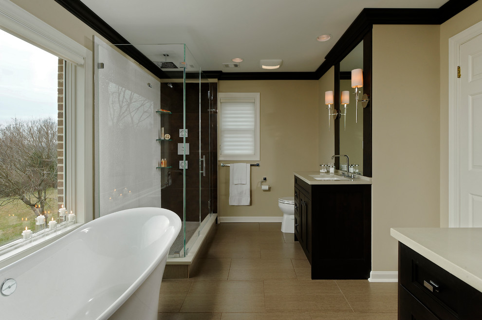 Medium sized classic ensuite bathroom in DC Metro with beaded cabinets, dark wood cabinets, a freestanding bath, an alcove shower, a one-piece toilet, multi-coloured tiles, glass tiles, beige walls, ceramic flooring, a submerged sink and solid surface worktops.