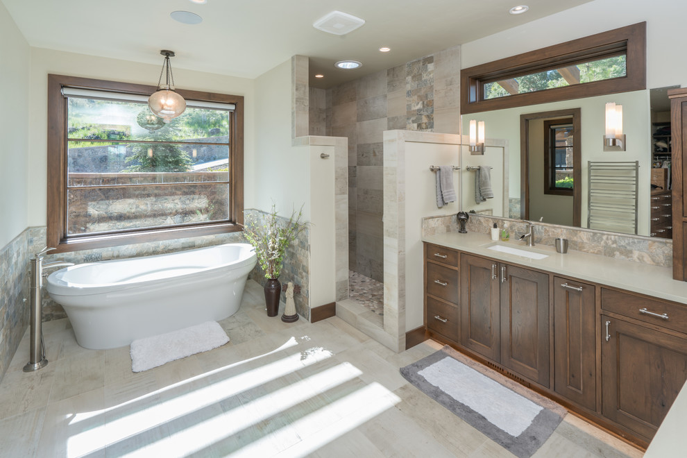 Foto di una grande stanza da bagno padronale stile americano con ante a filo, ante marroni, piastrelle grigie e top in quarzite