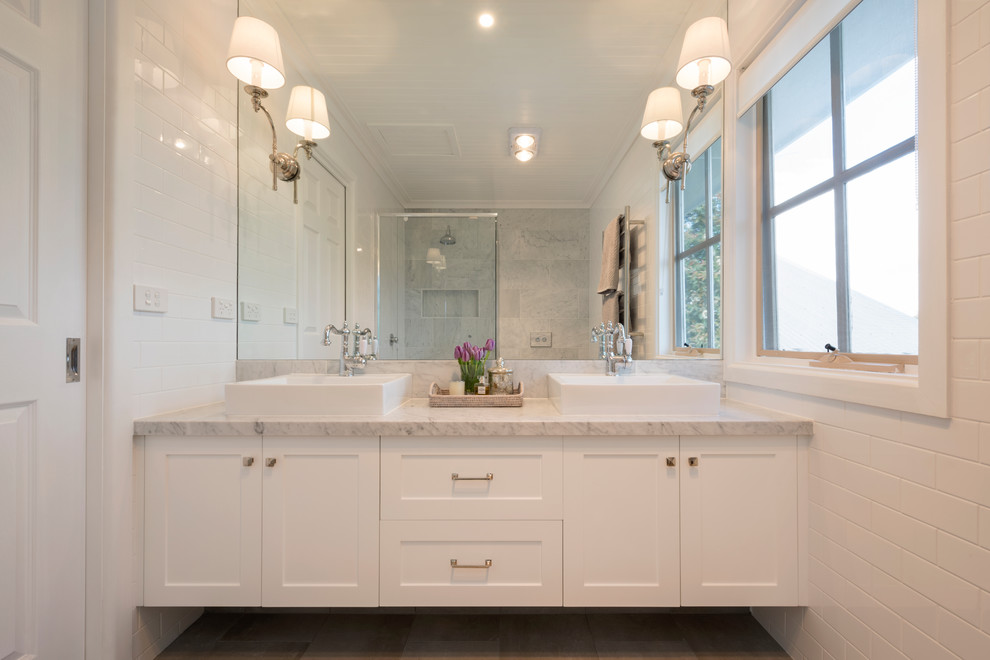 This is an example of a classic ensuite bathroom in Melbourne with shaker cabinets, white cabinets, white tiles, metro tiles, marble worktops, grey floors, a wall niche, double sinks, a floating vanity unit and a wood ceiling.