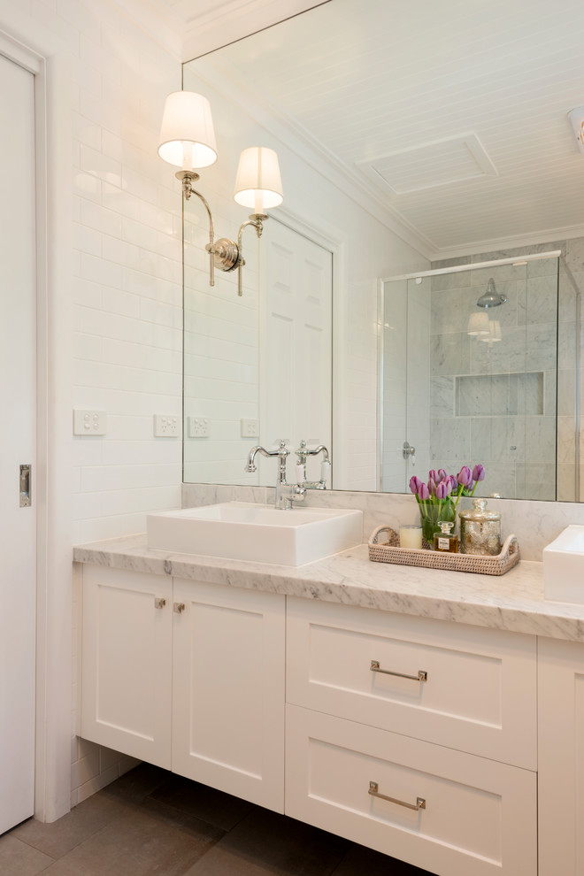 Klassisk inredning av ett en-suite badrum, med skåp i shakerstil, vita skåp, vit kakel, tunnelbanekakel, marmorbänkskiva och grått golv