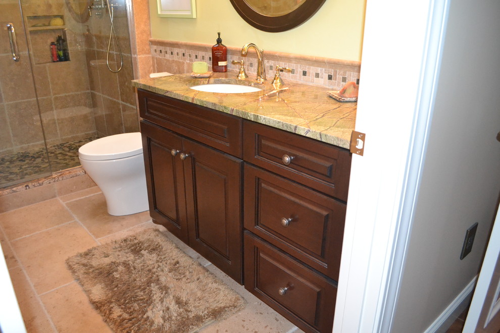 Idee per una stanza da bagno chic con lavabo sottopiano, ante con bugna sagomata, ante in legno bruno, top in granito e piastrelle beige