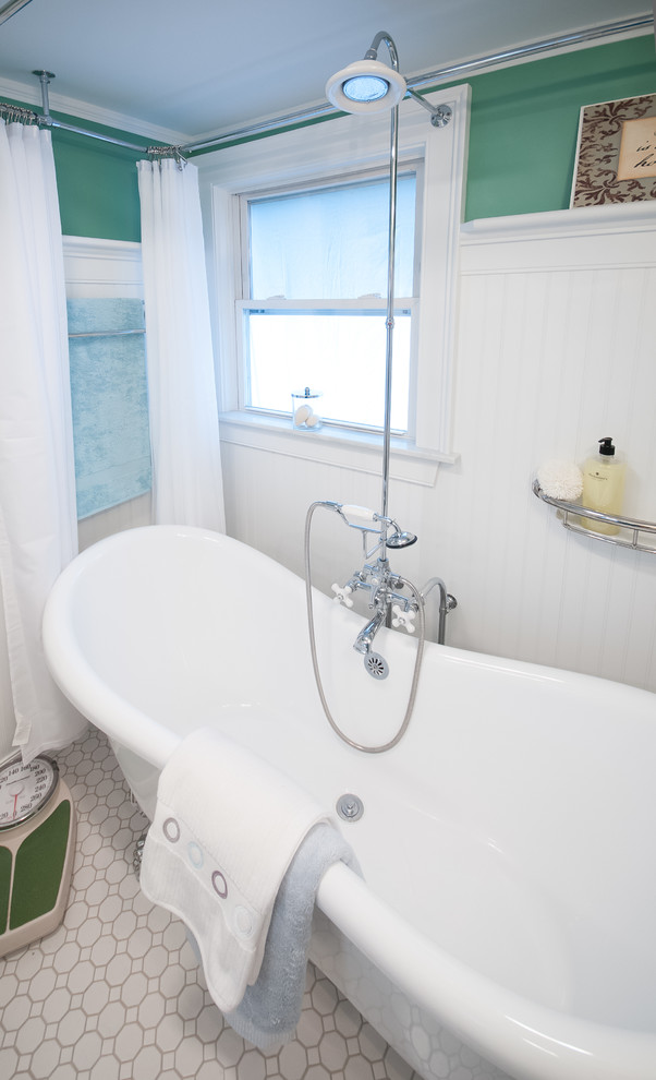Klassisk inredning av ett mellanstort en-suite badrum, med vit kakel, keramikplattor, ett badkar med tassar, en dusch/badkar-kombination, en toalettstol med separat cisternkåpa, ett piedestal handfat, gröna väggar och klinkergolv i keramik