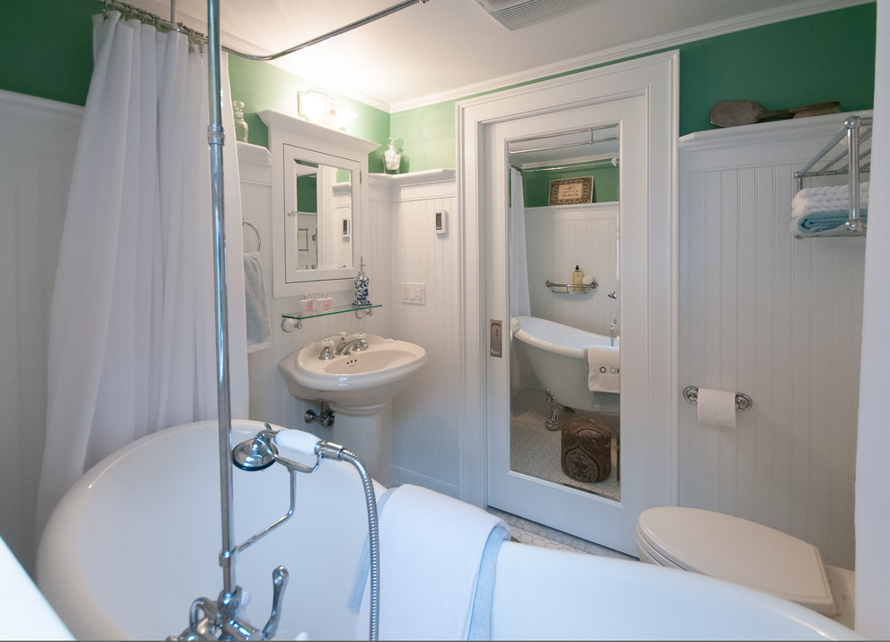 Cette image montre une salle de bain principale traditionnelle de taille moyenne avec un carrelage blanc, des carreaux de céramique, une baignoire sur pieds, un combiné douche/baignoire, WC séparés, un lavabo de ferme, un mur vert et un sol en carrelage de céramique.