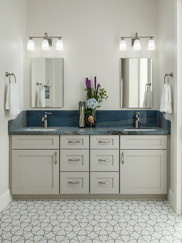 This is an example of a medium sized family bathroom in Phoenix with freestanding cabinets, black cabinets, a built-in bath, a shower/bath combination, a one-piece toilet, white tiles, ceramic tiles, white walls, cement flooring, a vessel sink, granite worktops, black floors, an open shower and blue worktops.