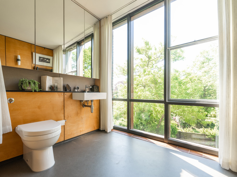 Ejemplo de cuarto de baño vintage de tamaño medio con lavabo suspendido, suelo gris, sanitario de pared y encimeras negras