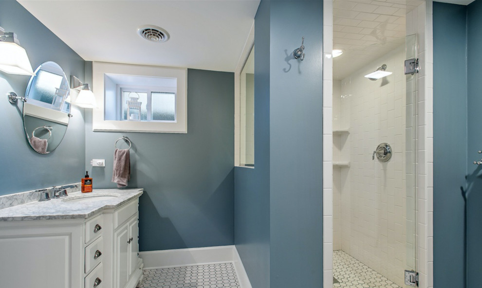Mittelgroßes Klassisches Badezimmer mit weißen Schränken, weißen Fliesen, Metrofliesen, blauer Wandfarbe, Waschtischkonsole und Marmor-Waschbecken/Waschtisch in Chicago