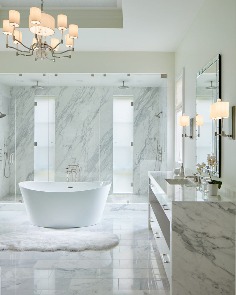 Inspiration för klassiska vitt en-suite badrum, med släta luckor, vita skåp, ett fristående badkar, en dubbeldusch, vit kakel, stenhäll, vita väggar, ett undermonterad handfat, vitt golv och dusch med gångjärnsdörr
