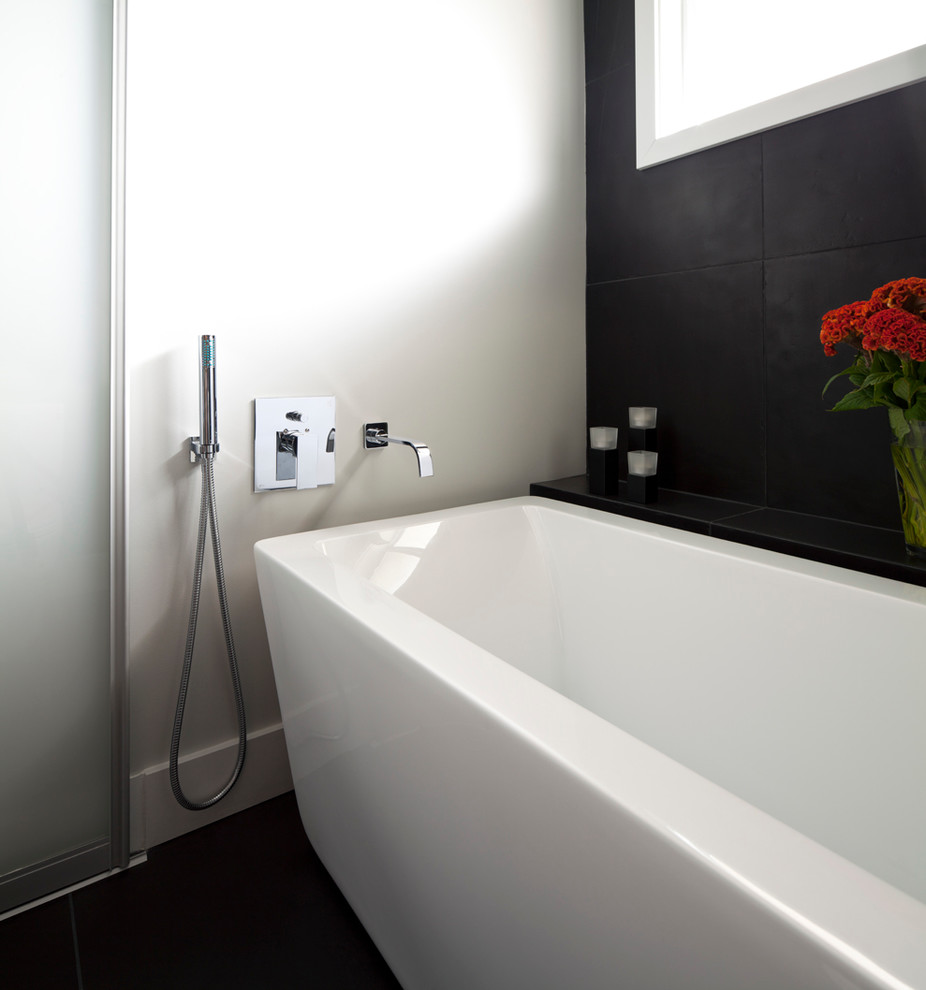 Ejemplo de cuarto de baño contemporáneo con bañera exenta y baldosas y/o azulejos negros