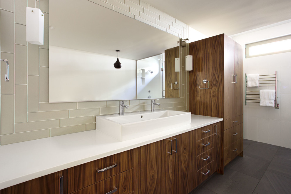 Modern inredning av ett en-suite badrum, med släta luckor, skåp i mellenmörkt trä, ett fristående badkar, en hörndusch, beige kakel, vita väggar, bänkskiva i kvarts och dusch med gångjärnsdörr