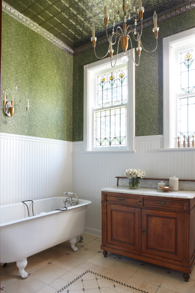 Cette image montre une salle de bain victorienne avec une baignoire sur pieds, un carrelage vert et un mur vert.