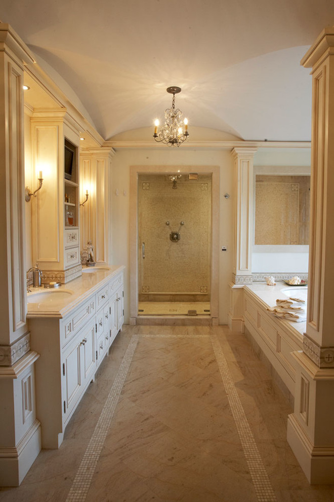 Foto di un'ampia stanza da bagno padronale tradizionale con lavabo da incasso, ante in legno chiaro, top in granito, vasca da incasso, doccia alcova, piastrelle beige, pareti beige e ante con riquadro incassato