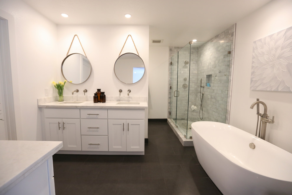 Example of a mid-sized farmhouse master gray tile and stone tile limestone floor bathroom design in Orange County with shaker cabinets, white cabinets, a one-piece toilet, white walls, an undermount sink and quartzite countertops