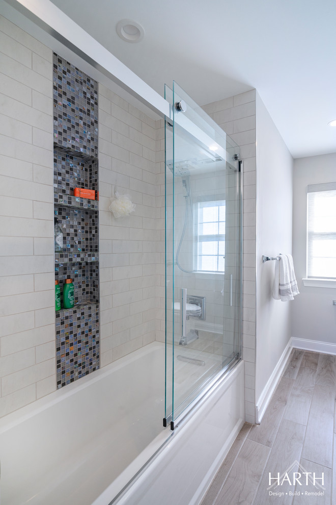 Пример оригинального дизайна: ванная комната среднего размера в стиле неоклассика (современная классика) с фасадами в стиле шейкер, синими фасадами, ванной в нише, душем над ванной, раздельным унитазом, белой плиткой, плиткой кабанчик, серыми стенами, полом из керамогранита, душевой кабиной, врезной раковиной, столешницей из искусственного кварца, бежевым полом, душем с раздвижными дверями и белой столешницей