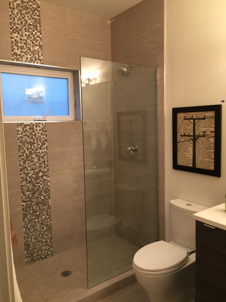 Bild på ett litet funkis badrum med dusch, med släta luckor, skåp i mörkt trä, en dusch i en alkov, en toalettstol med hel cisternkåpa, brun kakel, grå kakel, vit kakel, glaskakel, beige väggar, ett fristående handfat, bänkskiva i kvartsit och med dusch som är öppen