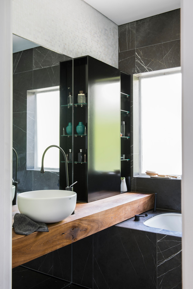 Inspiration for a small contemporary family bathroom in Sydney with freestanding cabinets, distressed cabinets, a submerged bath, a shower/bath combination, a wall mounted toilet, grey tiles, mosaic tiles, white walls, marble flooring, a vessel sink, wooden worktops, grey floors and an open shower.
