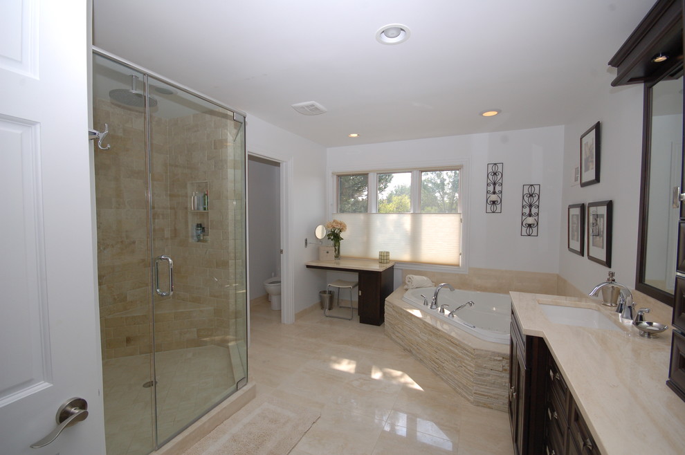 Inspiration for an expansive classic ensuite bathroom in Chicago with a submerged sink, freestanding cabinets, dark wood cabinets, a hot tub, a walk-in shower, a two-piece toilet, beige tiles, white walls and limestone flooring.