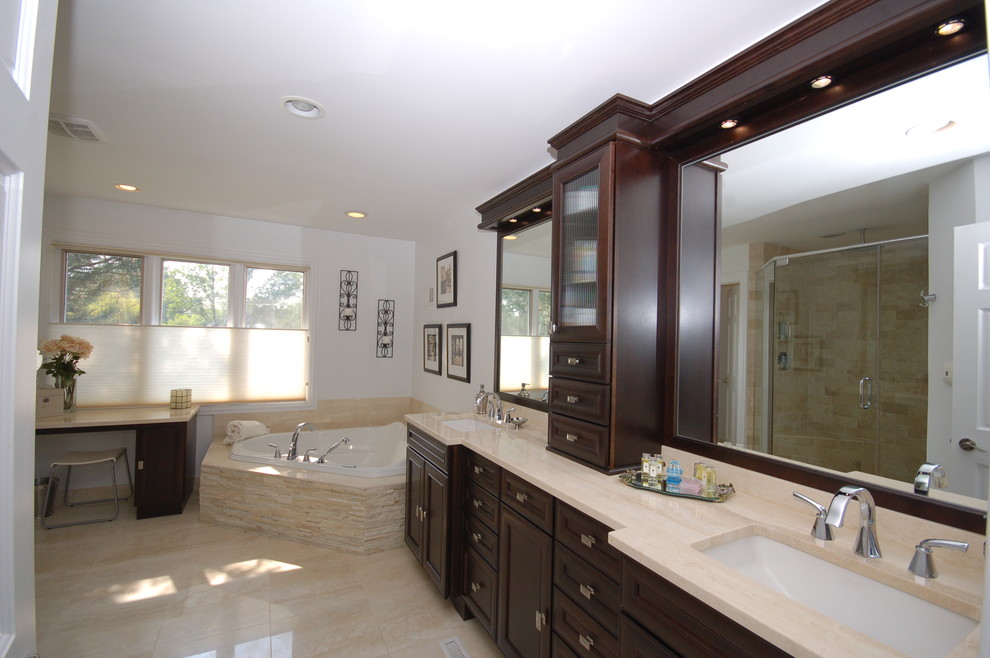 Exemple d'une très grande salle de bain principale chic en bois foncé avec un bain bouillonnant, un lavabo suspendu, une douche ouverte, WC séparés, un carrelage beige, un mur blanc, un sol en calcaire et un placard avec porte à panneau encastré.
