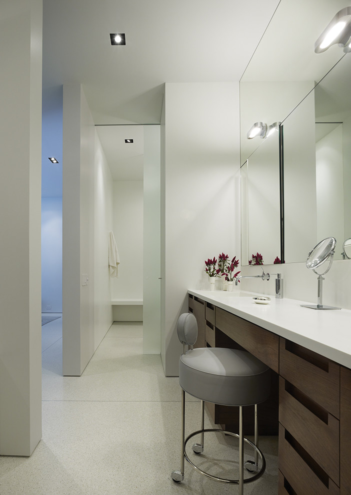 This is an example of a contemporary bathroom in Chicago with an integrated sink, flat-panel cabinets, dark wood cabinets and feature lighting.