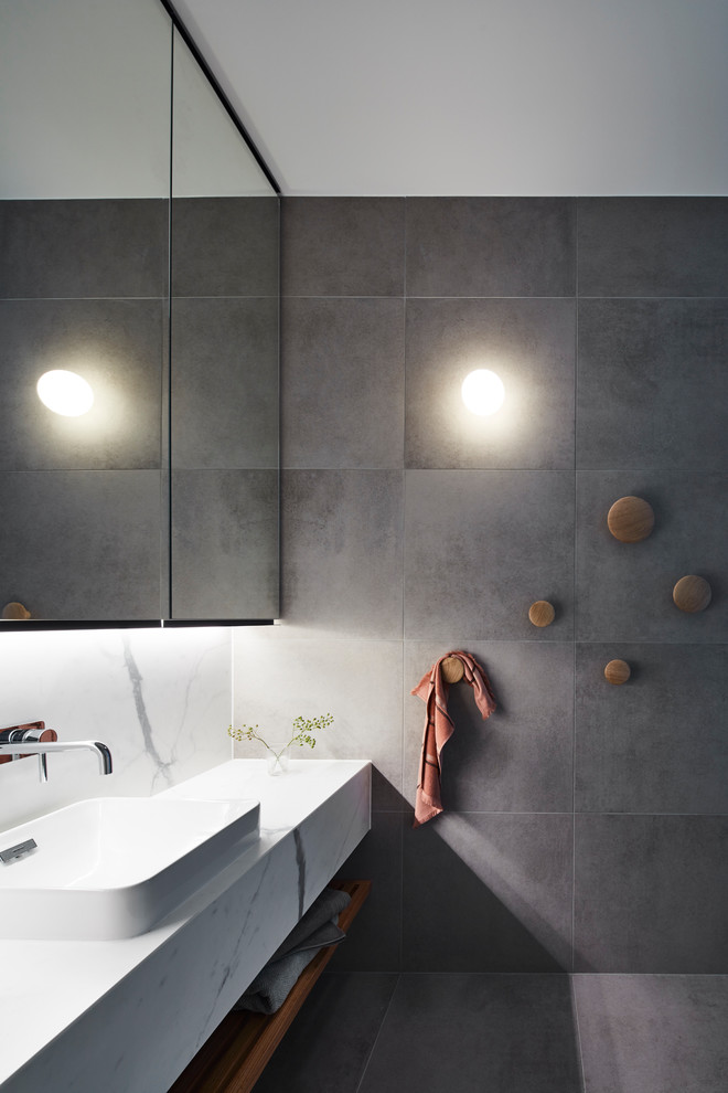 This is an example of a contemporary family bathroom in Melbourne with grey tiles, porcelain tiles, porcelain flooring, marble worktops, grey floors, white worktops and a vessel sink.