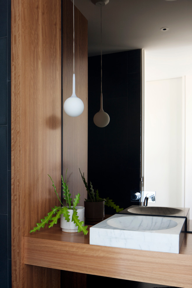 Ispirazione per una stanza da bagno contemporanea con ante in legno chiaro, lavabo a colonna e top in legno