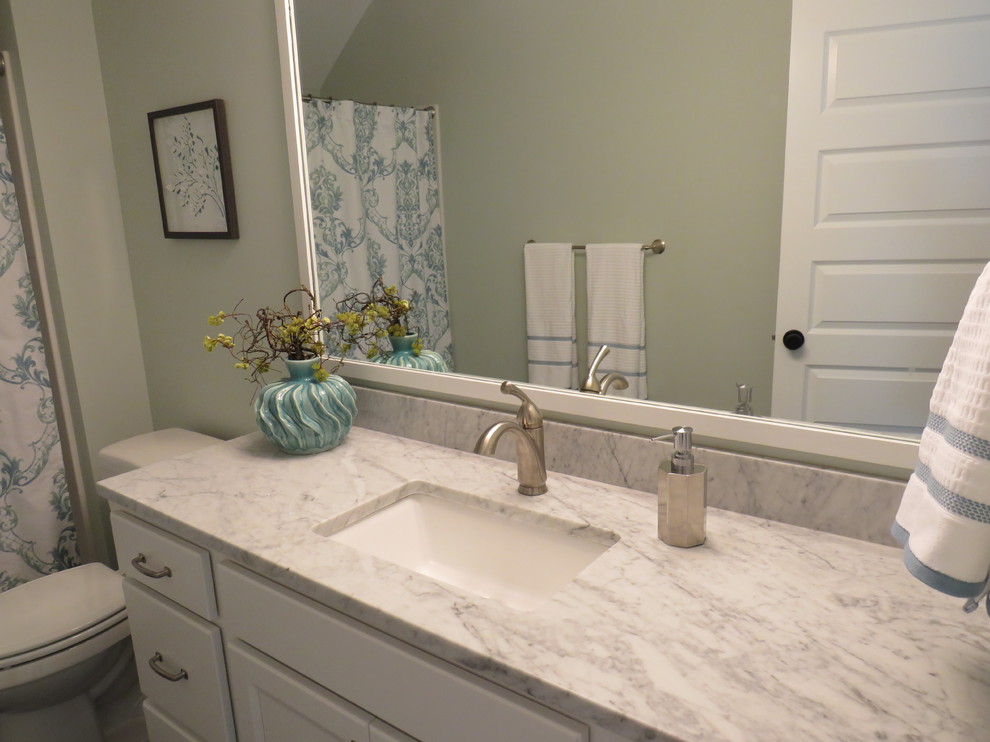 Idéer för mellanstora lantliga badrum med dusch, med luckor med infälld panel, vita skåp, ett hörnbadkar, en dusch/badkar-kombination, en toalettstol med separat cisternkåpa, gröna väggar, linoleumgolv, ett undermonterad handfat och marmorbänkskiva