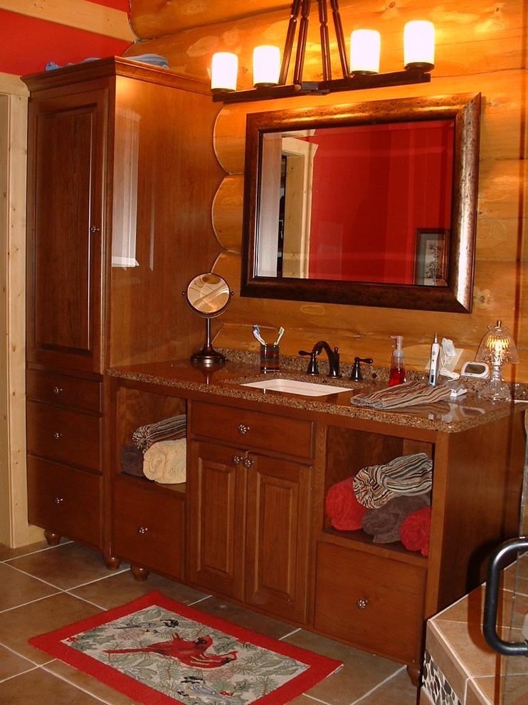 Example of a mountain style porcelain tile bathroom design in Other with an undermount sink, raised-panel cabinets, medium tone wood cabinets and quartz countertops
